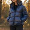 Frau in blauer Steppjacke mit Kapuze im Herbstlicht