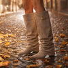 Beige Wildleder-Slouch-Boots auf herbstlichem Kopfsteinpflaster