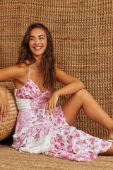 Zittende pose in roze patchwork jurk met speelse uitstraling