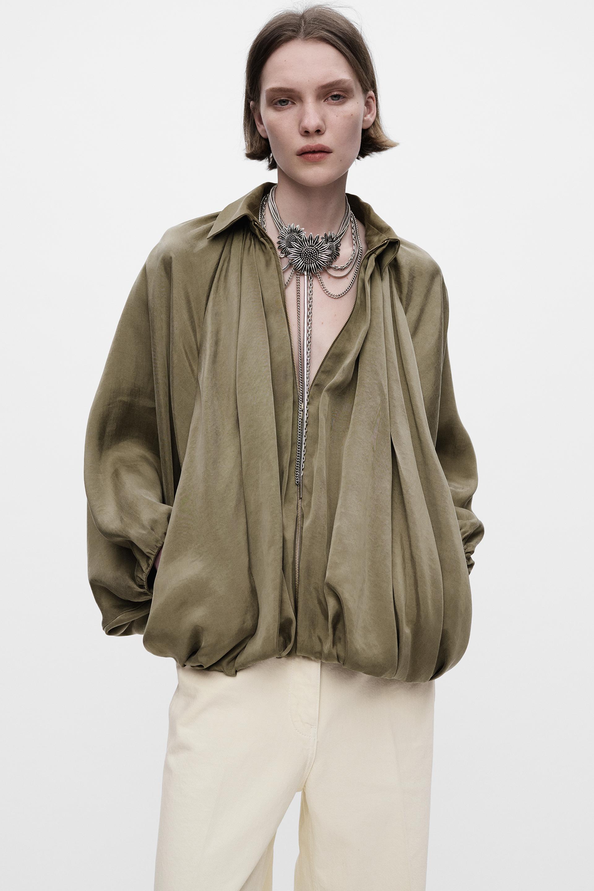 Model trägt Isandra Draped Statement Jacket in Olivgrün mit Oversized-Fit