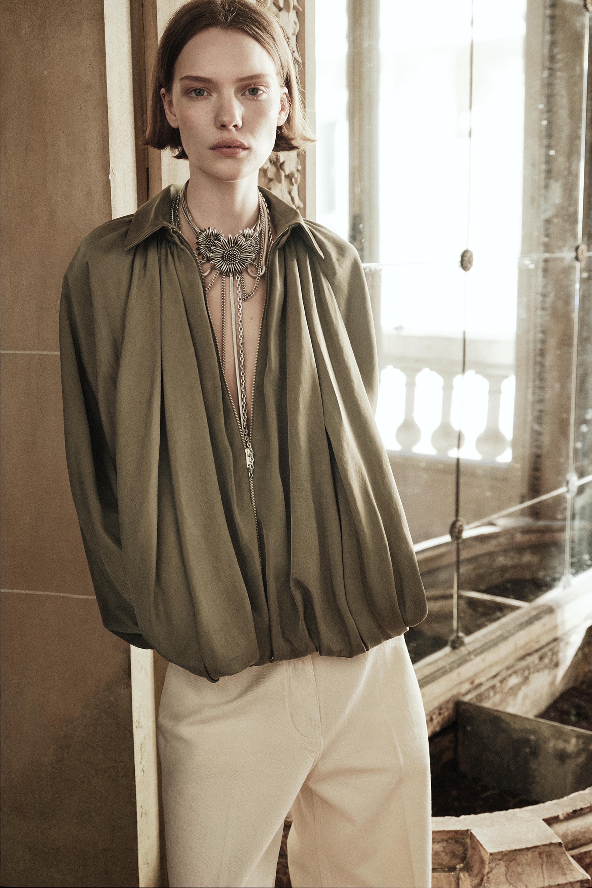 Model trägt Isandra Draped Statement Jacket in Olivgrün mit Oversized-Fit