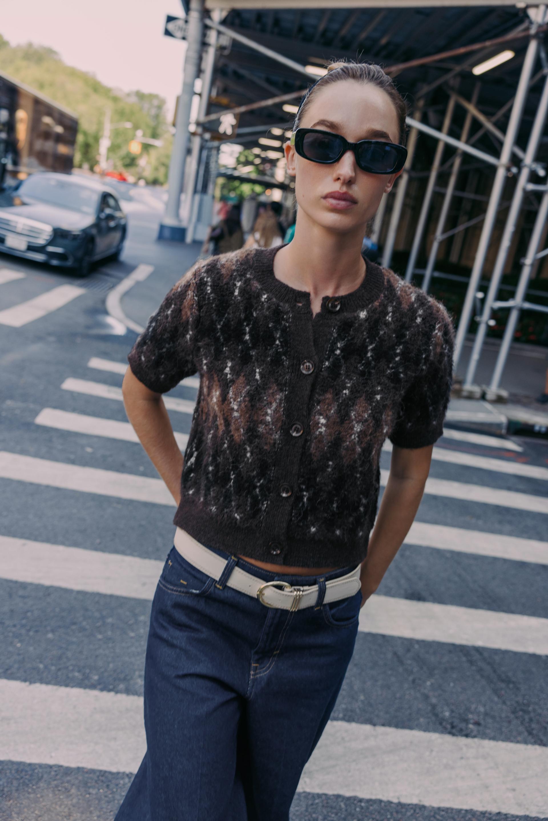 kurze braune strickjacke mit argyle-muster und knöpfen flach gelegt