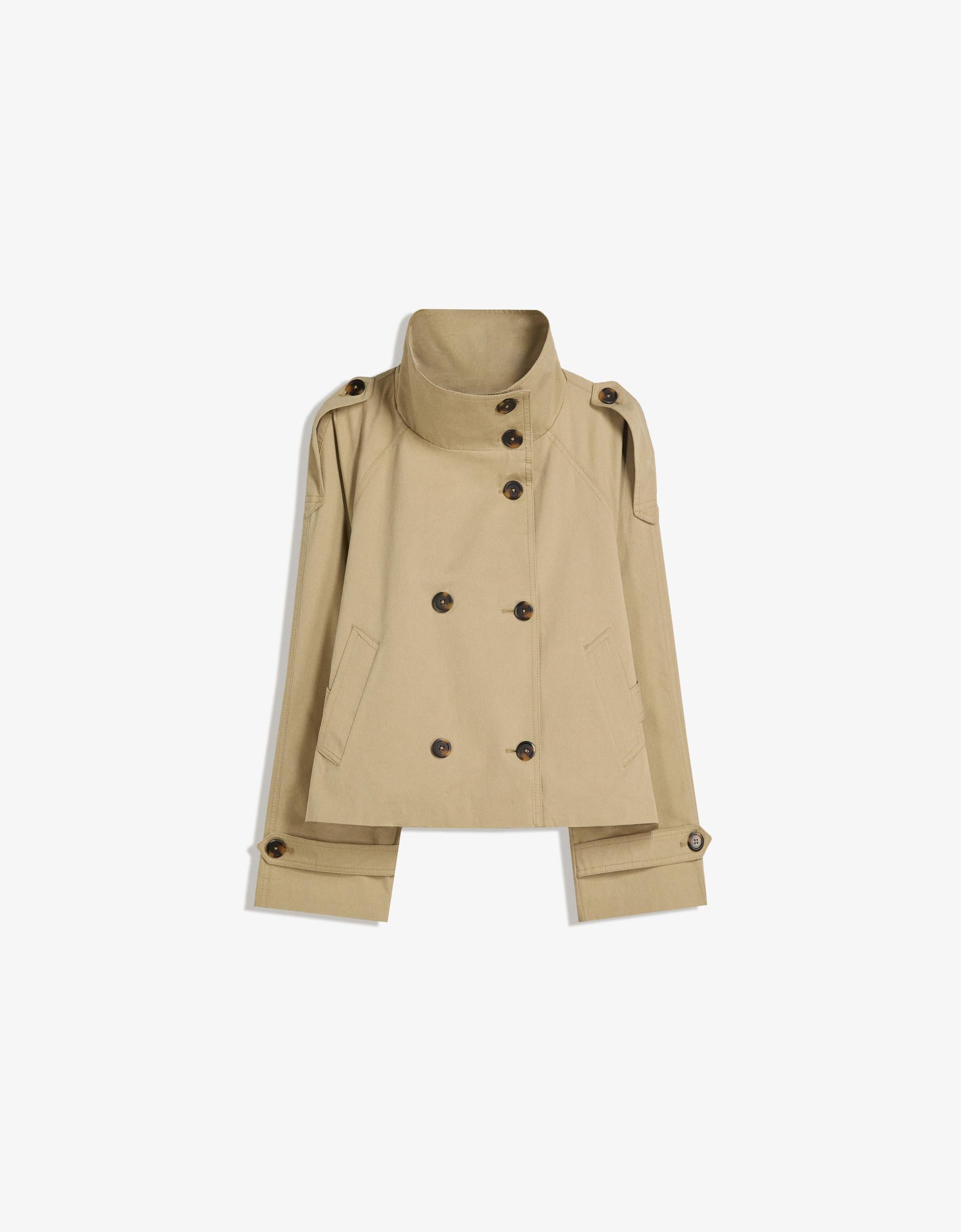 beige kurzer trenchcoat flach fotografiert mit hohem stehkragen