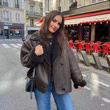 Frau trägt Nevada Luxe Winterjacke in Dunkelbraun auf der Straße
