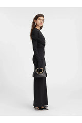 schwarze ringtasche mit goldenem griff zu schwarzem one-shoulder kleid