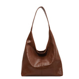 Aurelia Schoudertas met bijpassende clutch, weergegeven in bruine tint, geschikt voor werk en casual gebruik.