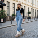 Modell mit taupe Winterstiefeln mit Fellbund und Denim-Latzhose – trendiges Winteroutfit.