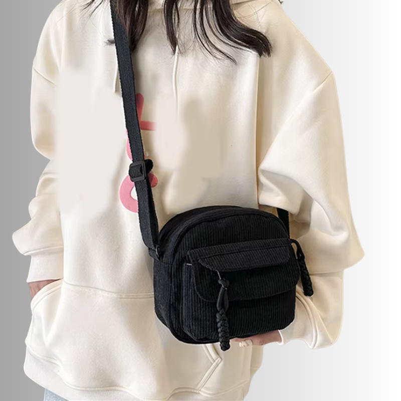 Zwart tasje gedragen over witte hoodie