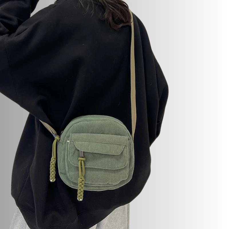 Groen tasje gedragen crossbody op zwarte outfit