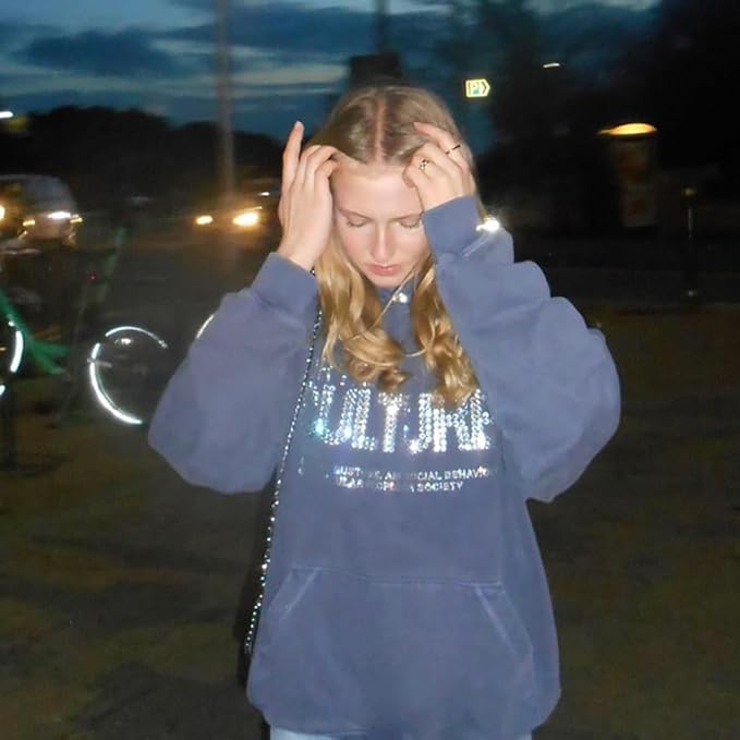 modell trägt blauen hoodie for the culture mit strass vor graffiti wand