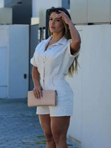 Witte denim jumpsuit gestyled met clutch