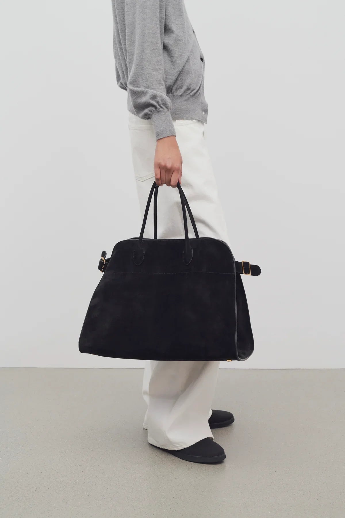 zwarte suède tas gedragen door model
