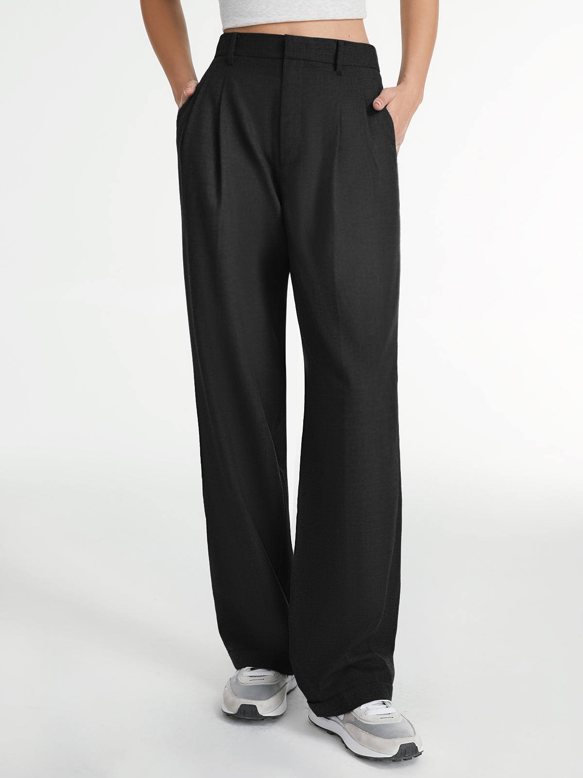 Model in grijze pantalon met witte tanktop
