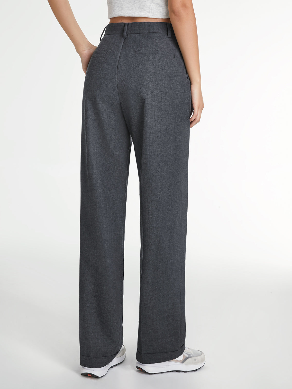 Model draagt grijze straight leg broek met wit topje
