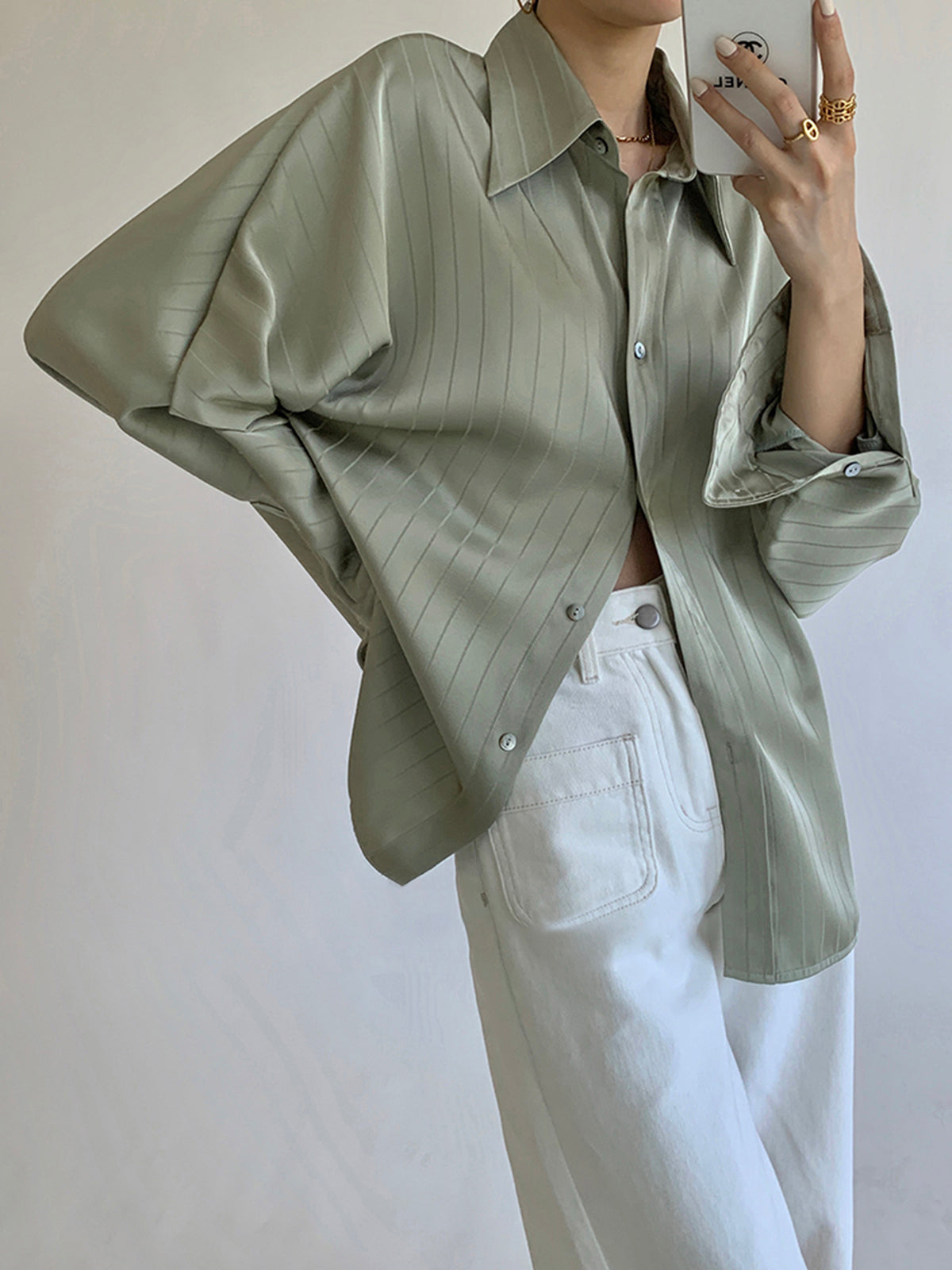 Groene blouse los geknoopt over witte rok
