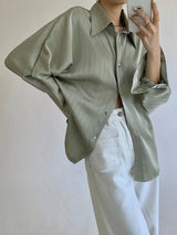 Groene blouse los geknoopt over witte rok

