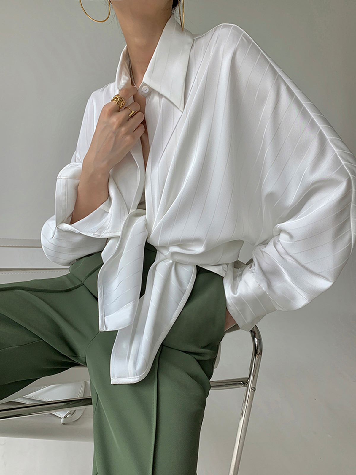 Witte oversized blouse gestyled met groene broek
