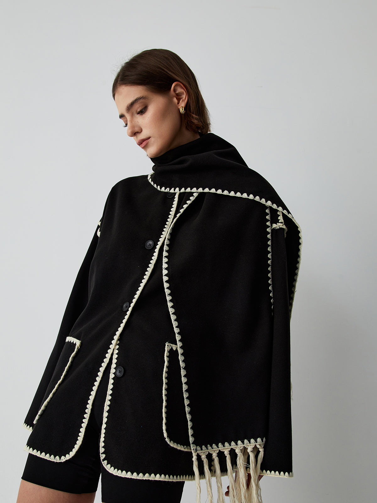 Model trägt Seraphina CapeCoat mit integriertem Schal in Schwarz
