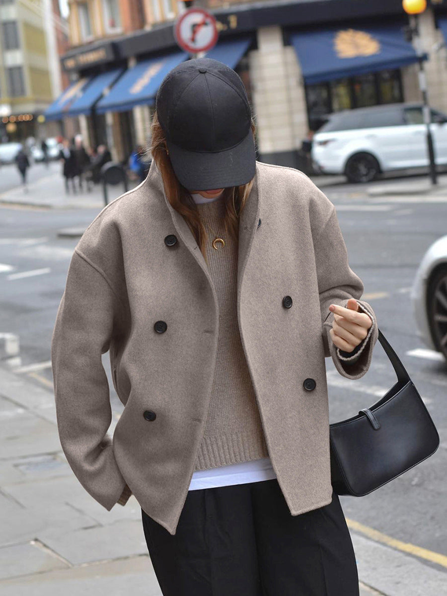 Model met tas in oversized jas in beige
