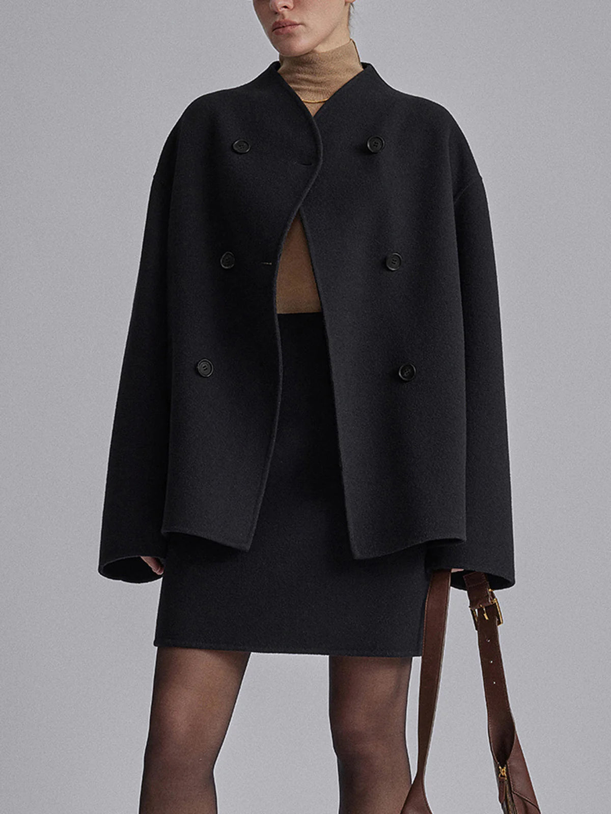 Model in zwarte oversized jas met rok
