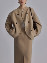 Model in beige jas met dubbele knopen en bijpassende rok
