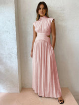Model in roze cut-out jurk met taille-accent
