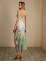 Model draagt elegante asymmetrische bloemenjurk

