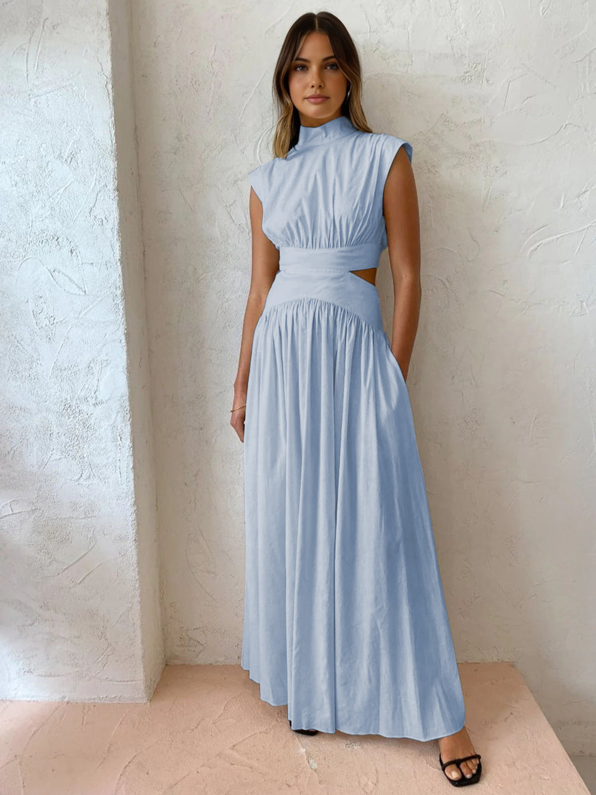 Model draagt blauwe jurk met cut-out
