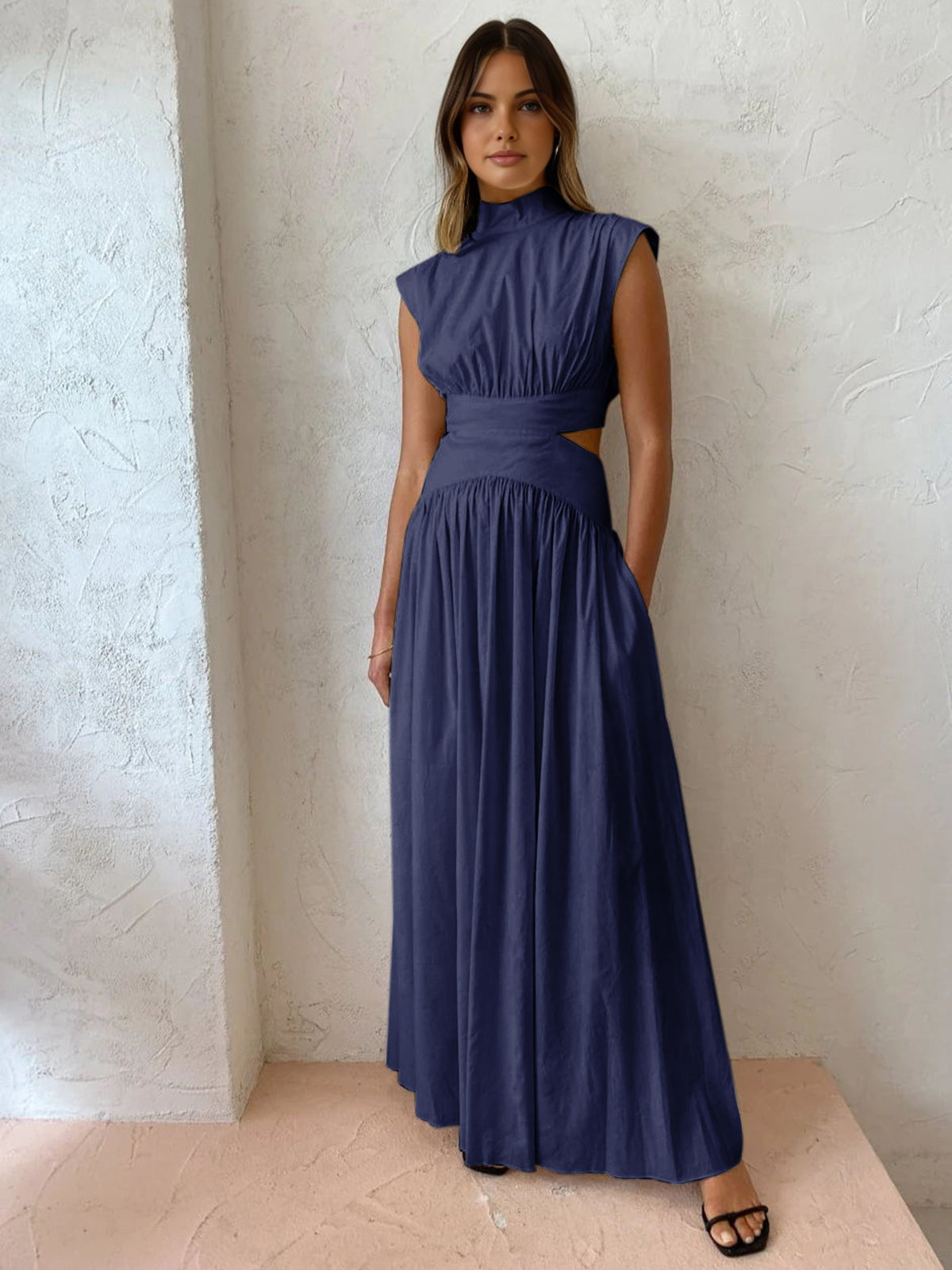 Model in donkerblauwe maxi jurk met hoge hals
