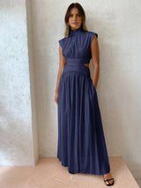 Model in donkerblauwe maxi jurk met hoge hals
