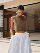 Model draagt Liora cropped top in goudbruin met witte rok
