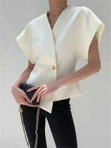 Model draagt witte Velina blouse met gouden knoop
