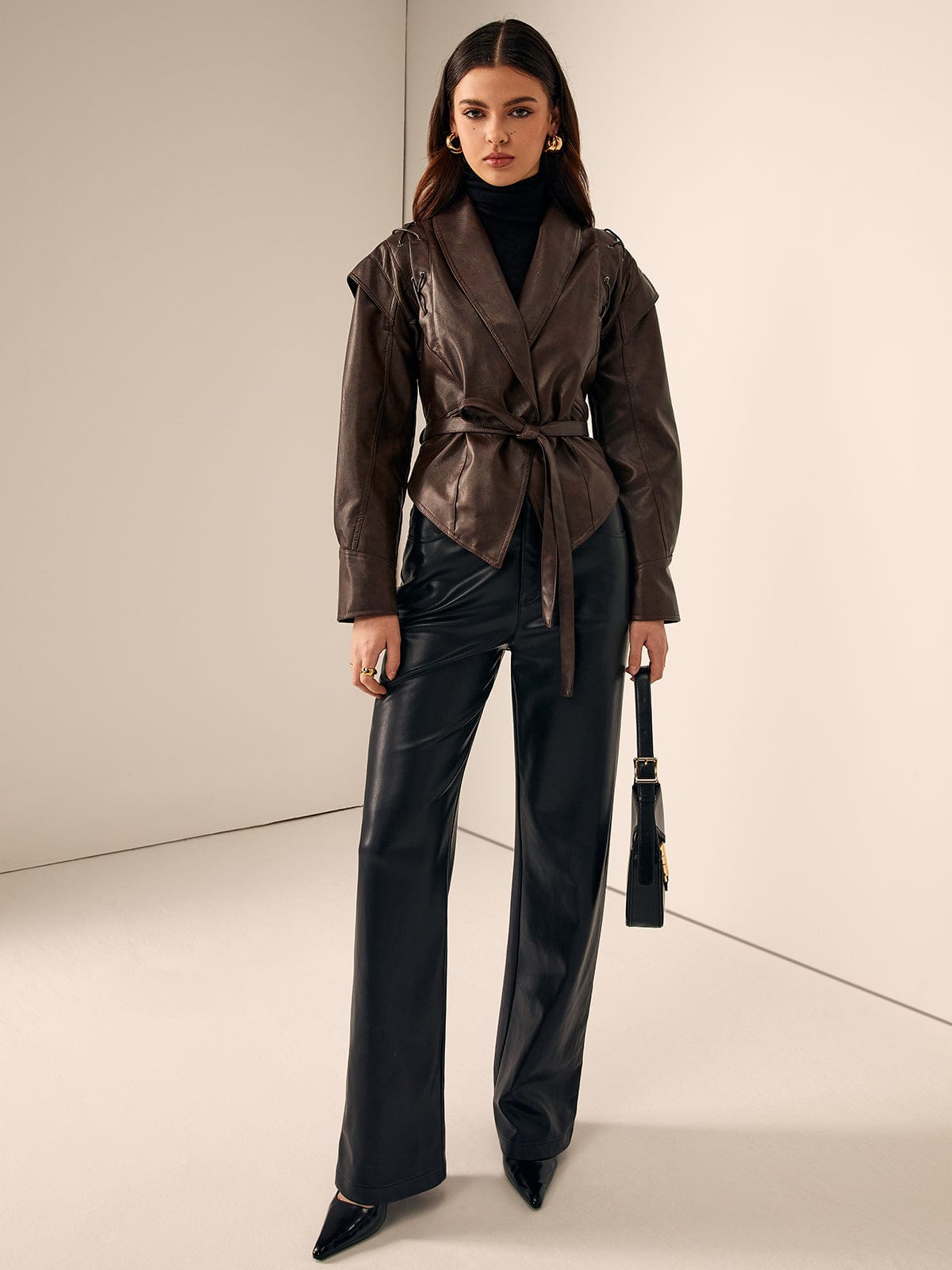 Model trägt braune Lederjacke mit Gürtel und goldenen Ohrringen