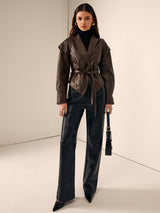 Model trägt braune Lederjacke mit Gürtel und goldenen Ohrringen