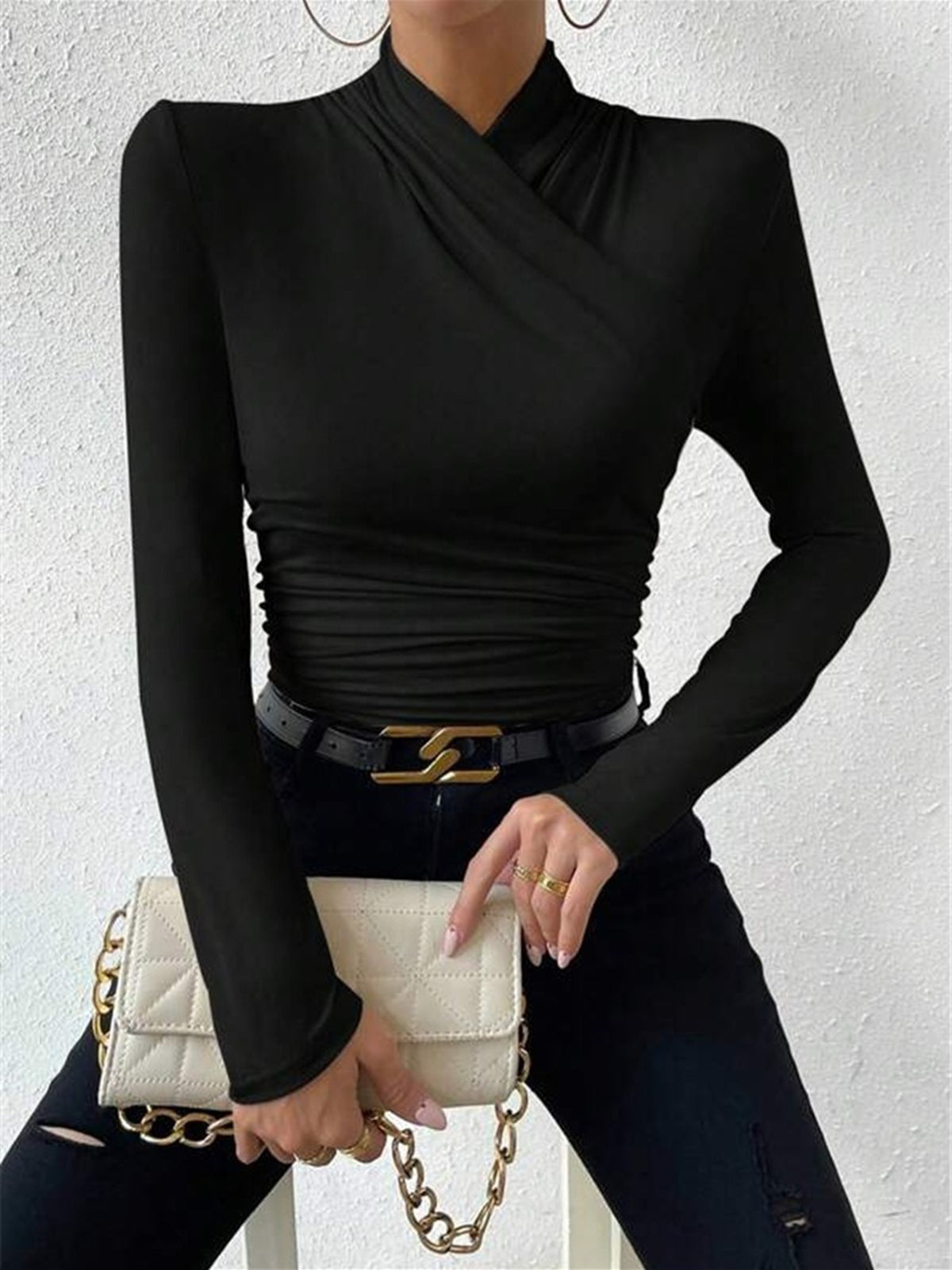 Model in zwarte cross-over top en jeans

