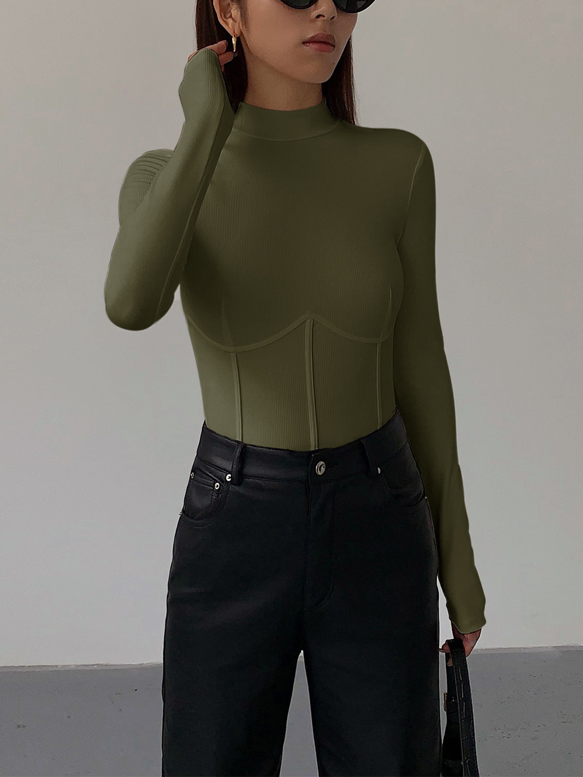 Groene Meliora top gecombineerd met zwarte jeans
