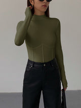 Groene Meliora top gecombineerd met zwarte jeans
