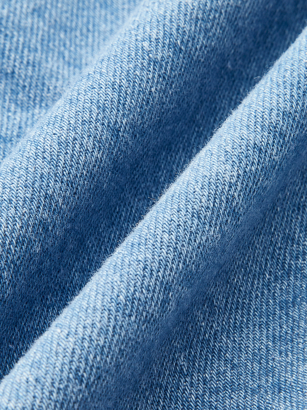 vrouw draagt stoere denimjurk met gespen
