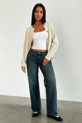 dunkelblaue mid waist wide-leg jeans kombiniert mit weißem top und cardigan