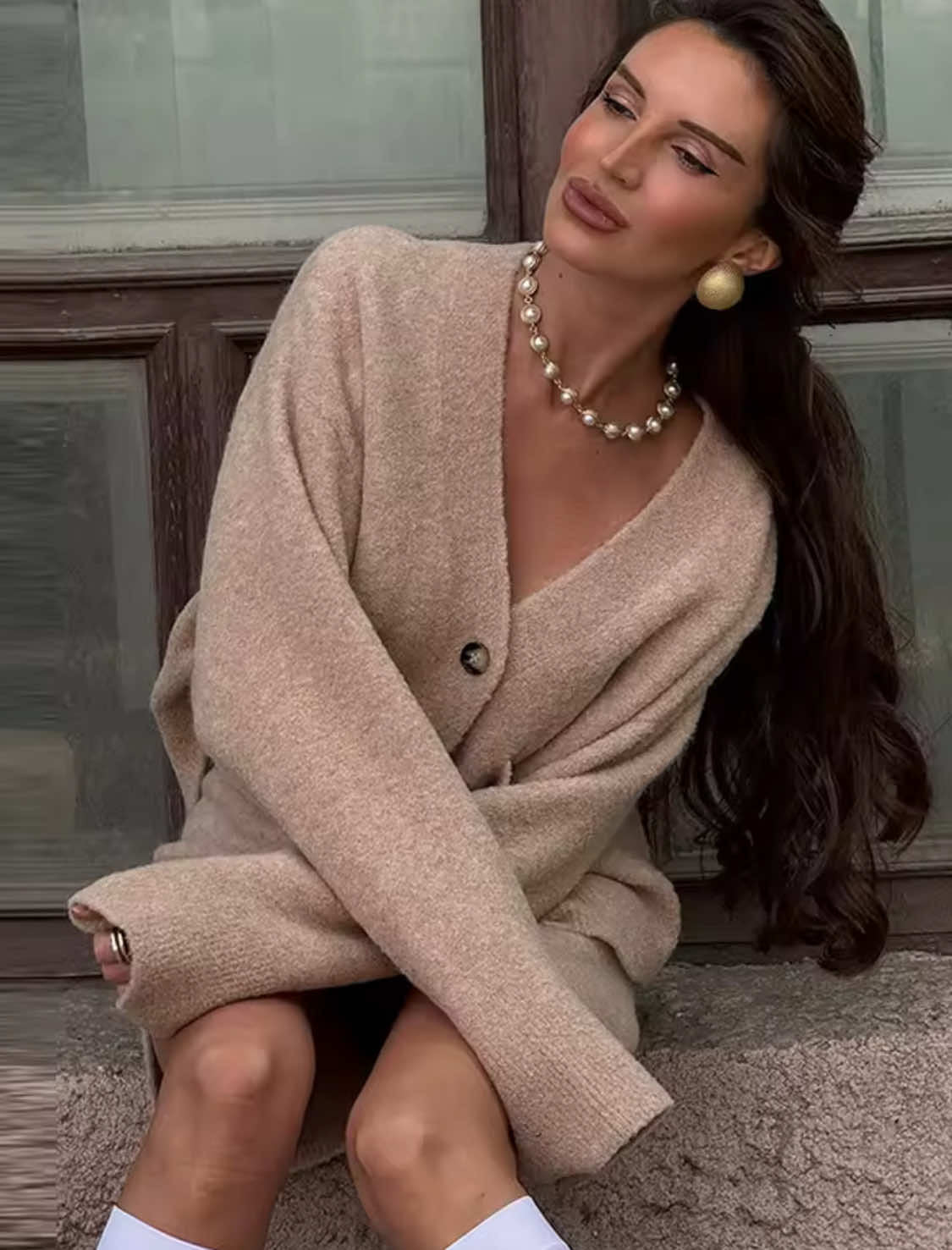 nahaufnahme von beige cardigan mit großen knöpfen und taschen