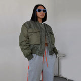 Frau trägt olivgrüne Bomberjacke im Oversized-Stil