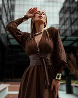 Frau trägt braunes elegantes Maxi-Kleid mit V-Ausschnitt