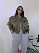 Frau trägt olivgrüne Bomberjacke im Oversized-Stil