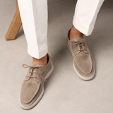beige suède instappers voor heren gedragen met witte broek