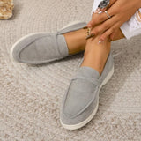 grijze suède loafers voor dames op een tapijt
