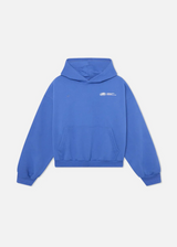 Model in blauem Oversize Hoodie am Strand
