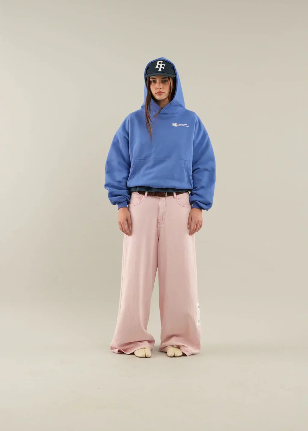 Model in blauem Oversize Hoodie am Strand
