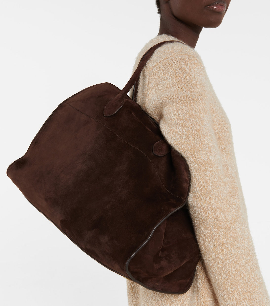 vrouw met beige outfit en grote suède shopper tas