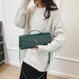 vrouw draagt groene luxe crossbody tas met geweven patroon
