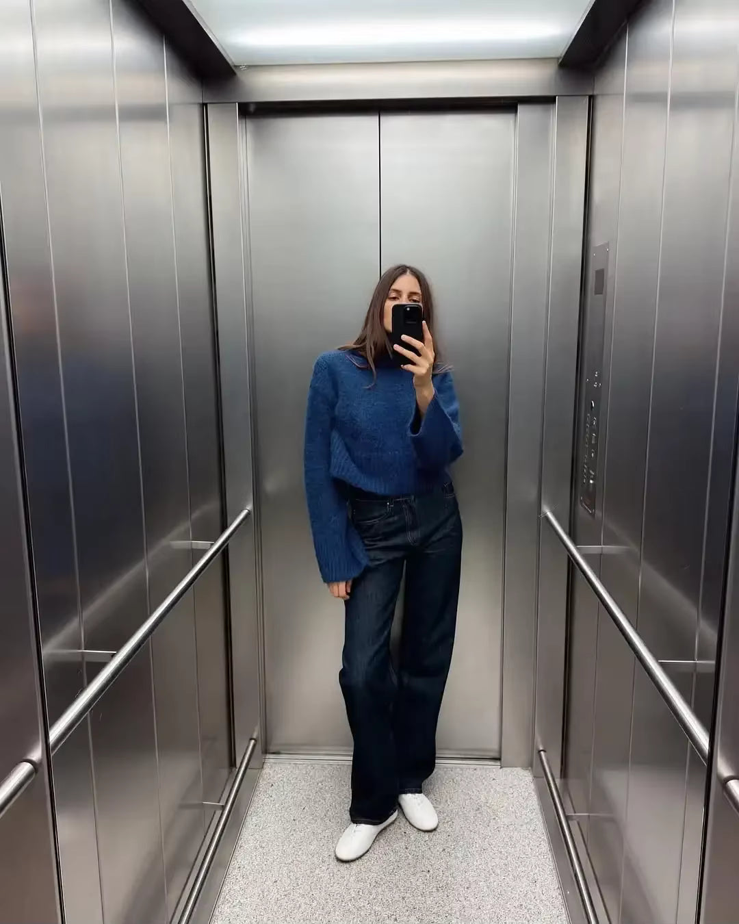 frau trägt blauen cropped strickpullover mit rollkragen und weiten ärmeln